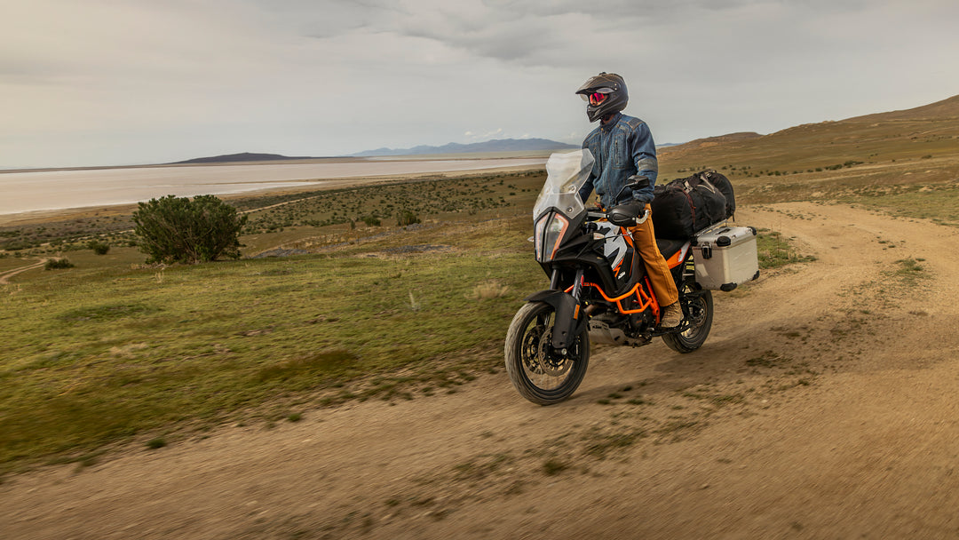 Man riding his motorcycle along the scenic seaside, taking in the outdoor beauty while dressed in his Whiskey Denim Adventure Fit - 6th Gen jeans.