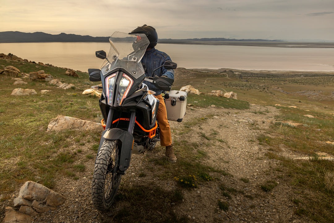 Motorcycle enthusiast cruising by the seaside, relishing the outdoor view in his Whiskey Denim Adventure Fit - 6th Gen jeans.