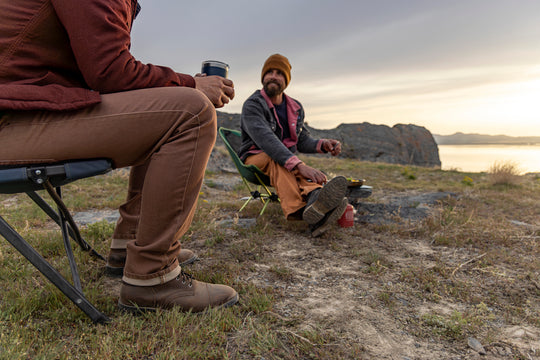 Two friends enjoying outdoor camping, both wearing Tobacco Brown Denim - Slim Fit - 6th Gen Bulletprufe Jeans.