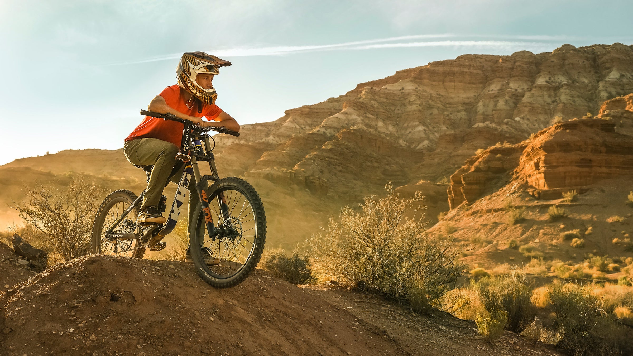 man mountain biking wearing helmet and bulletprufe denim green jeans
