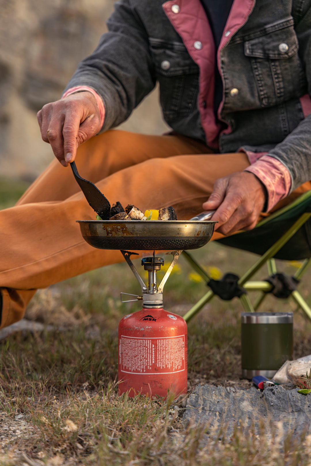 In his rugged Bulletprufe Jeans - Whiskey Denim Slim Fit, this man cooks up a storm with his favorite campfire cuisine, blending style and adventure seamlessly.