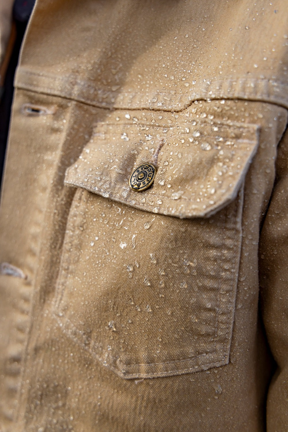 Rain droplets on the New Overland Jacket. Your trusted companion for conquering the unknown.